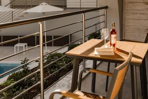 a table and a bottle of wine on a balcony at Ostria Village in Syvota