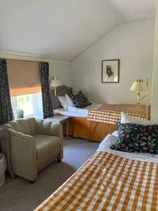 a hotel room with two beds and a couch at Bångbro Herrgård in Kopparberg