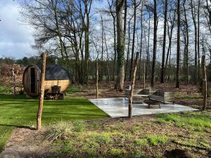 a cabin in the middle of a park with trees at Wellness in de NATUUR in Neede