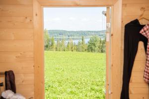 a door to a cabin with a view of a field at Itärajan Helmi in Tohmajärvi