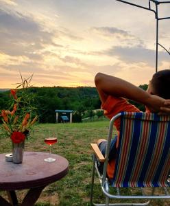 a man sitting in a chair at a table with a glass of wine at Sunčana Strana Fruške Gore in Sremski Karlovci +60 photos