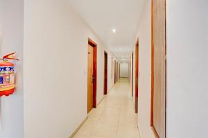 a hallway with white walls and a long corridor at Super Townhouse Oak Arvindo Park Indira Nagar Formerly Rama Inn in Vibhuti Khand