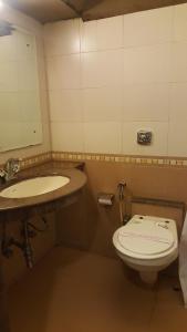a bathroom with a toilet and a sink at Privilege Inn in Mumbai