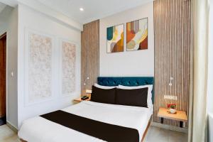 a bedroom with a large white bed with a blue headboard at Super Townhouse Oak Arvindo Park Indira Nagar Formerly Rama Inn in Vibhuti Khand
