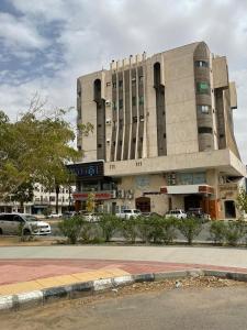 a large building with cars parked in front of it at Dvina Hotel دفينا in Tabuk