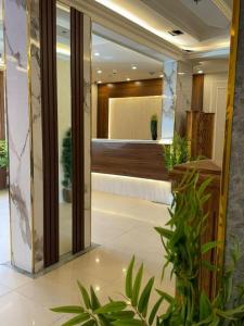 a lobby with potted plants in a building at Dvina Hotel دفينا in Tabuk