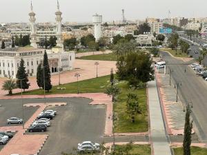 a city with cars parked in a parking lot at Dvina Hotel دفينا in Tabuk