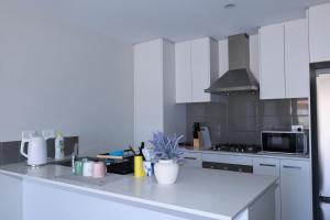 a kitchen with white cabinets and a white counter top at Sweet Home Property 7A Kewdale in Perth +5 photos