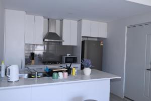 a white kitchen with a sink and a refrigerator at Sweet Home Property 7A Kewdale in Perth