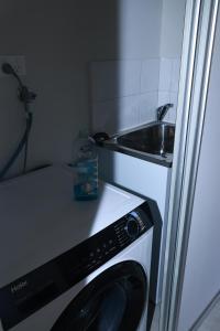 a kitchen with a washing machine and a sink at Sweet Home Property 7A Kewdale in Perth