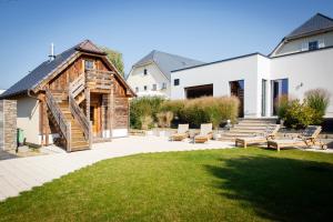 a backyard with a wooden building and some benches at Ringhotel Landhaus Nicolai "Hotel Garni" in Lohmen