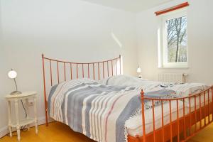 a bedroom with a bed with a striped blanket at Appartement Moin! in Hohwacht