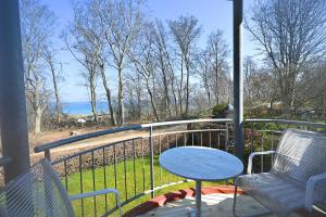 a porch with two chairs and a table on a balcony at Appartement Moin! in Hohwacht