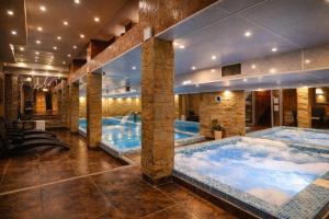 a large indoor pool with two large hot tubs at Premier Prezident Garni Hotel and Spa in Sremski Karlovci