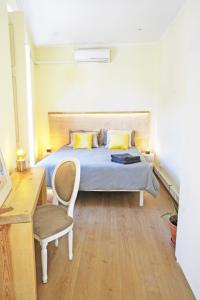 a bedroom with a bed with a chair and a desk at Casa Saint Yves in Setúbal