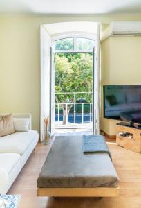 a living room with a white couch and a large window at Casa Saint Yves in Setúbal