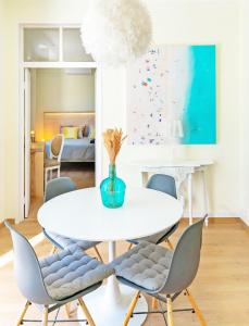 a dining room with a white table and chairs at Casa Saint Yves in Setúbal