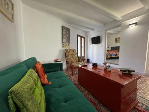 a living room with a green couch and a table at Casa Lui Codrut in Alcalà de Xivert