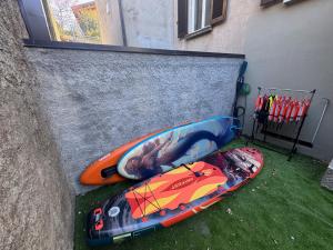 two kayaks sitting on the grass next to a wall at Immobillario - Domus Palmae in Domaso +35 photos