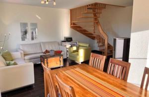 a living room with a table and a living room with a couch at Wellenläufer Breege in Breege +17 photos