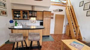a kitchen with a counter and stools in a room at Ferienwohnung Wellenreiter 200 m zum Strand Fewo strandnah mit Balkon Parkplatz Wlan in Karlshagen
