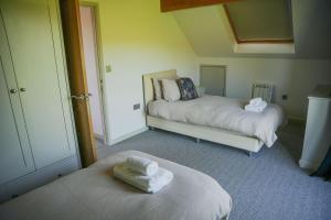 two beds in a room with towels on them at Maple in Knighton