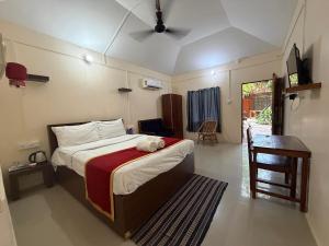 a bedroom with a large bed and a table and a desk at Havelock Farms Resort in Havelock Island +113 photos