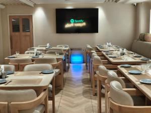 a room with tables and chairs and a tv on the wall at Hotel Tushar Elegant in Ghaziabad