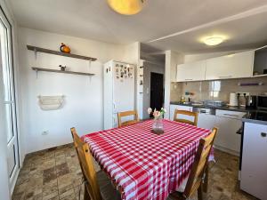 a kitchen with a table with a red and white checkered table cloth at Apartman Gloria Sajam - Panorama in Belgrade