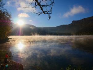 a person is standing on the shore of a lake at Camping Le SIGNAL Nantua in Nantua +9 photos