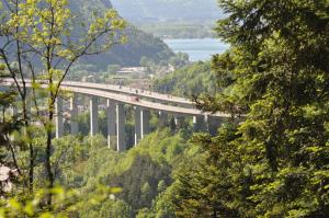 a bridge over a river with cars on it at Camping Le SIGNAL Nantua in Nantua
