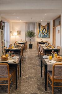 a dining room with long tables and chairs at Kallithea INN in Platres