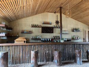 a bar in a room with a wall with bottles at TSIAZOMPANIRY ISLAND LODGE in Ambohimiadana