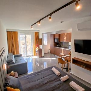 a living room with a couch and a tv at The Black Onyx in Il-Gżira