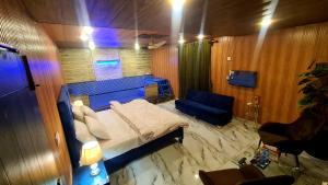 a bedroom with a bed and a blue chair at Hotel Five Rivers - 2 Min to Allama Iqbal International Airport, Lahore in Lahore