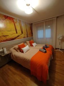 a bedroom with a large bed with an orange blanket at Domus Redes in Pola de Laviana