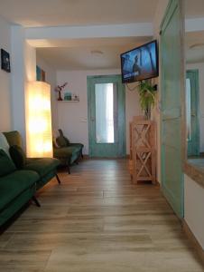 a living room with a flat screen tv on the wall at Ca la Carme in Villalba dels Arcs