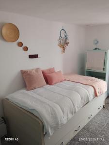 a bedroom with a bed with pink and white sheets at Ca la Carme in Villalba dels Arcs
