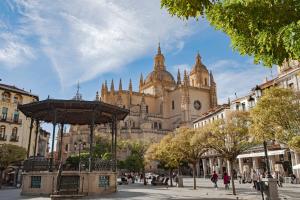 a large building with a clock tower in a city at San Miguel in Segovia