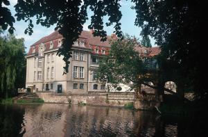 un grande edificio accanto a un corpo idrico di Jagdschloss-Bellin a Bellin
