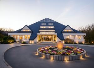 a building with a flower garden in front of it at Lázeňský hotel Pyramida in Františkovy Lázně