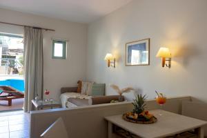 a living room with a couch and a table at Giannoulis - Grand Bay Beach Resort (Exclusive Adults Only) in Kolymvari