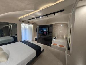 a bedroom with a bed and a tub and a television at Twentyseven Luxury Suite in Catania +4 photos