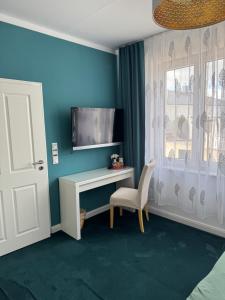 a room with a desk and a tv and a window at Pension "Zum Romröder Steingarten" in Romrod