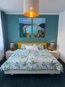 a bedroom with a bed with a painting on the wall at Pension "Zum Romröder Steingarten" in Romrod