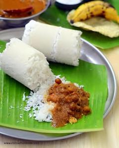 a green plate with rice and a piece of food at Haven roots in Trivandrum