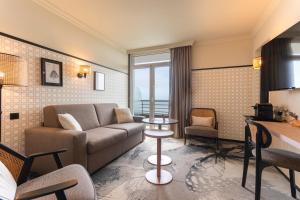 a living room with a couch and a table at Mercure Granville Le Grand Large in Granville