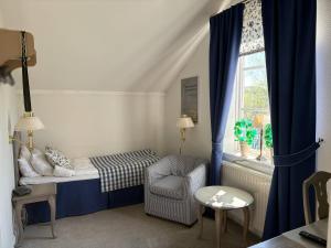 a small room with a bed and a chair and a window at Bångbro Herrgård in Kopparberg