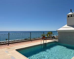 a swimming pool with a view of the ocean at Apartamentos HC Burriana Playa in Nerja