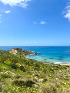 a view of a beach with the ocean in the background at Sunset Haven Manikata - Walking distance to Golden Bay in Manikata